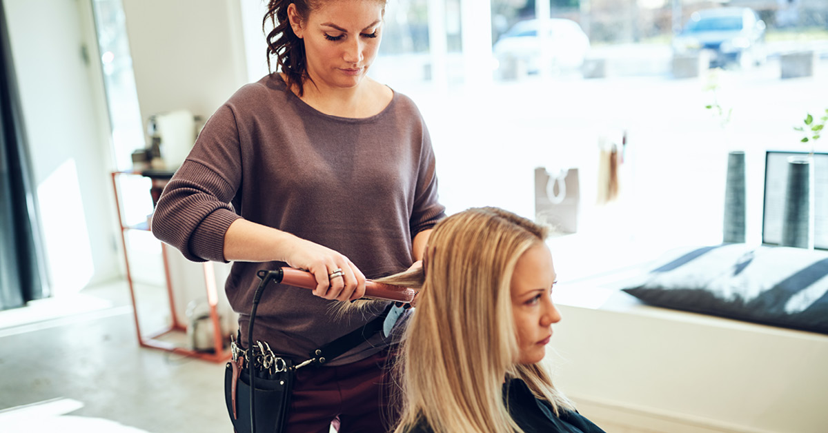 A woman sitting getting her hair done at a hairdressers