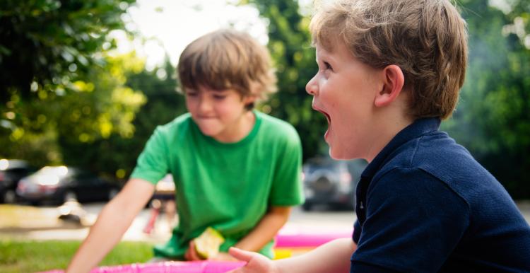 Children playing outside in a paddling pool