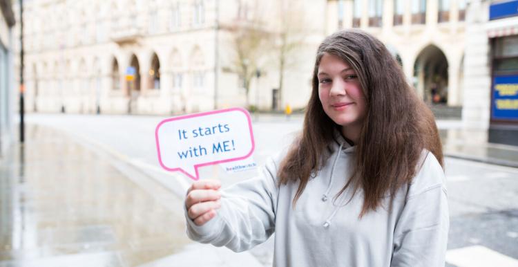 girl holding it starts with me sign