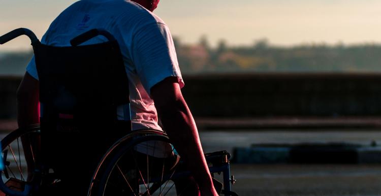 Boy pushing himself in a wheelchair.