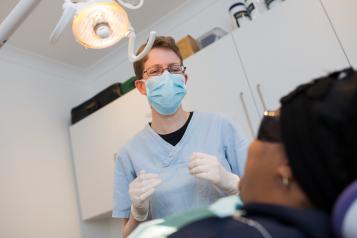 Dentist talking with their patient sitting in the chair