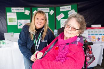 Healthwatch staff member speaking to an elderly woman in a wheelchair