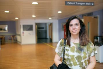 A woman standing in the main reception at hospital.