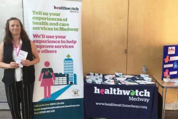 Healthwatch Medway's Debbie standing in front of our stall at the event held by One Voice