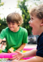 Children playing outside in a paddling pool